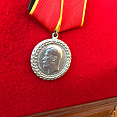 Рамка-коллаж с маузером (муляж-копия), копией медали «За беспорочную службу в полиции», лентой «За верность традициям»